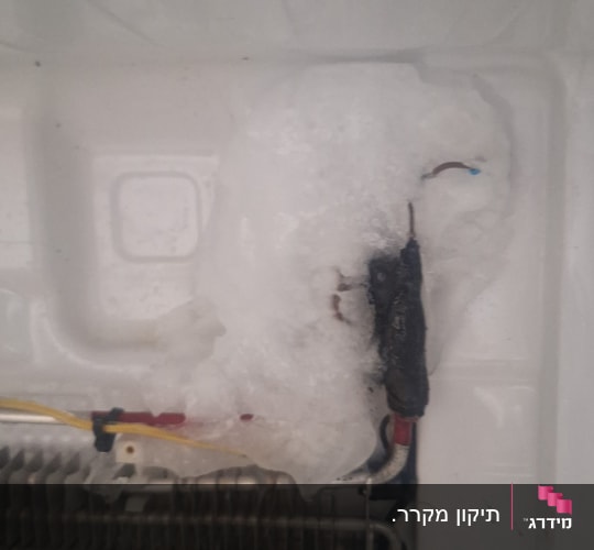 חלק פנימי של מקרר עם קרח וקורוזיה